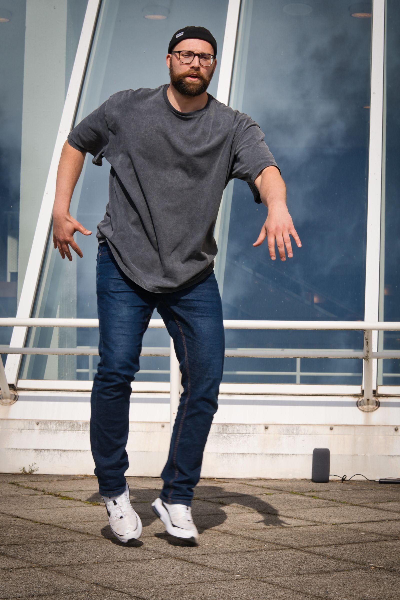 Jonas Beck in a beanie and glasses, dancing outdoors