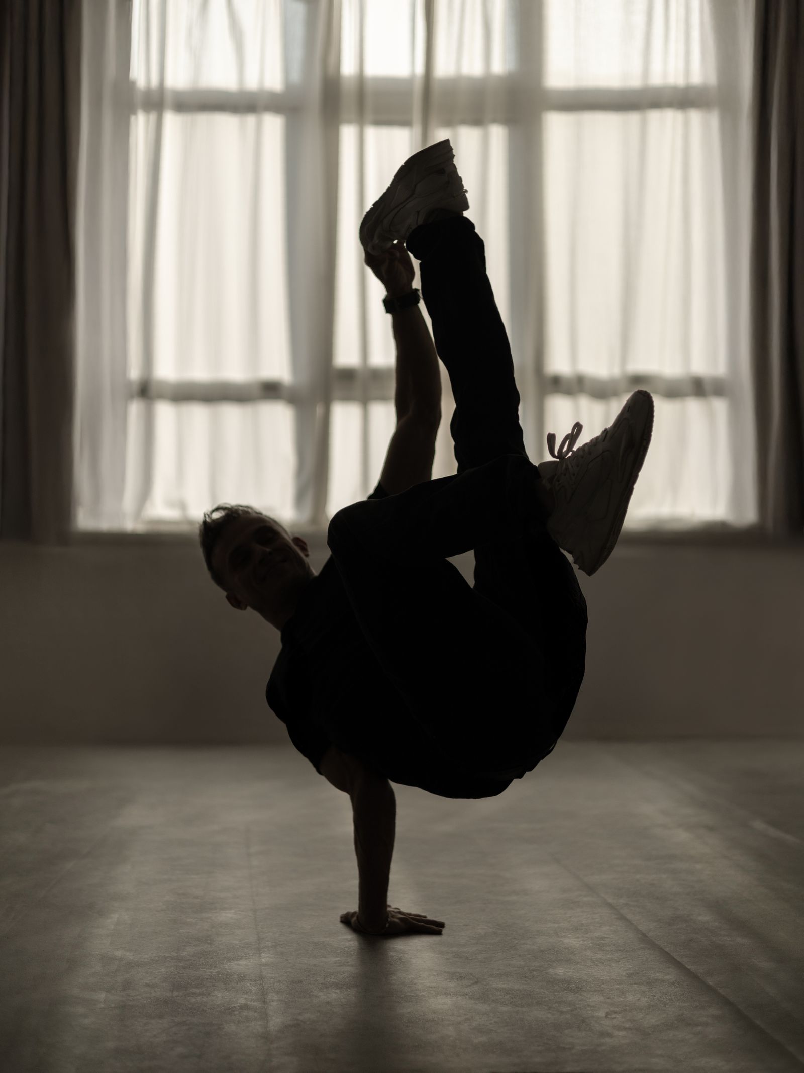 Silhouetted dancer balancing in a handstand freeze