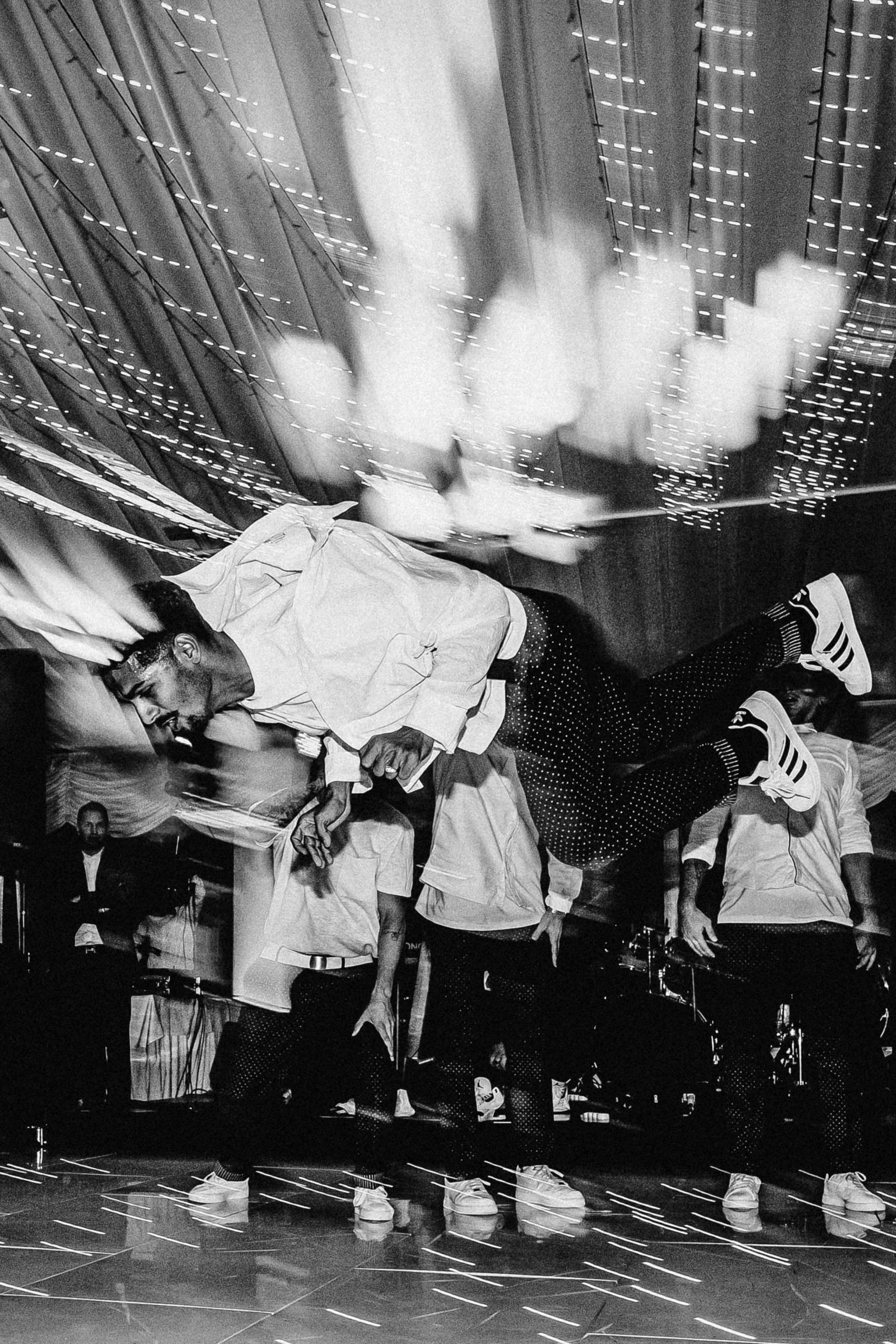 Black and white motion-blurred shot of dancers performing on stage