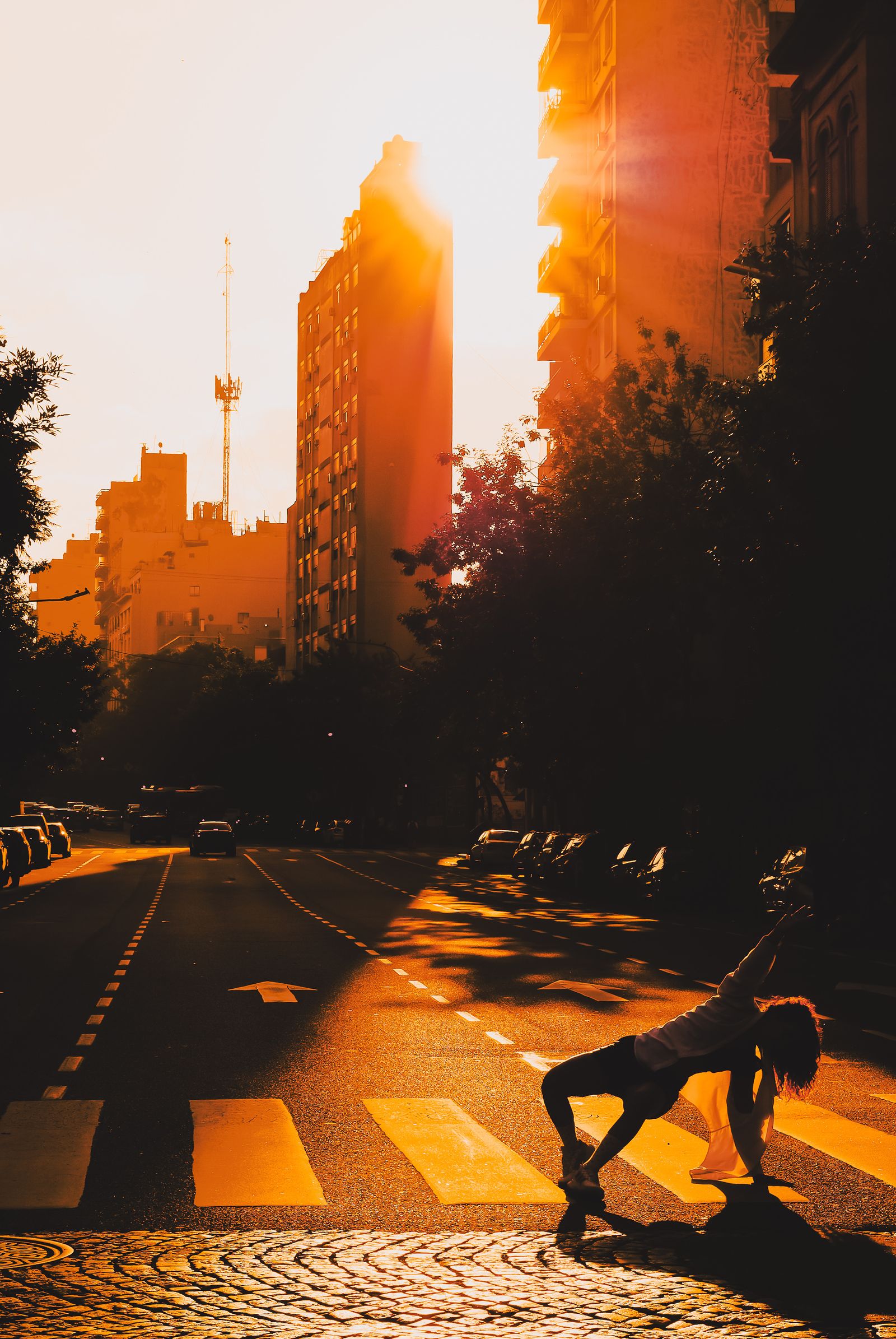 Dancer moving in a city crosswalk at golden hour