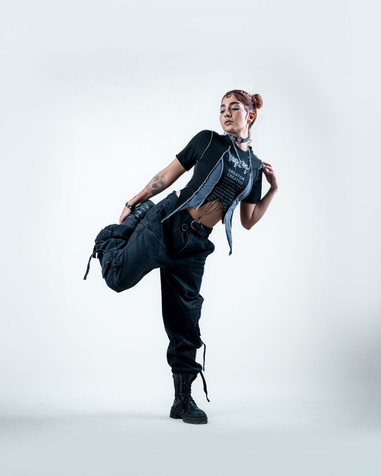 Maya Delgado standing in black cargo pants against a white backdrop