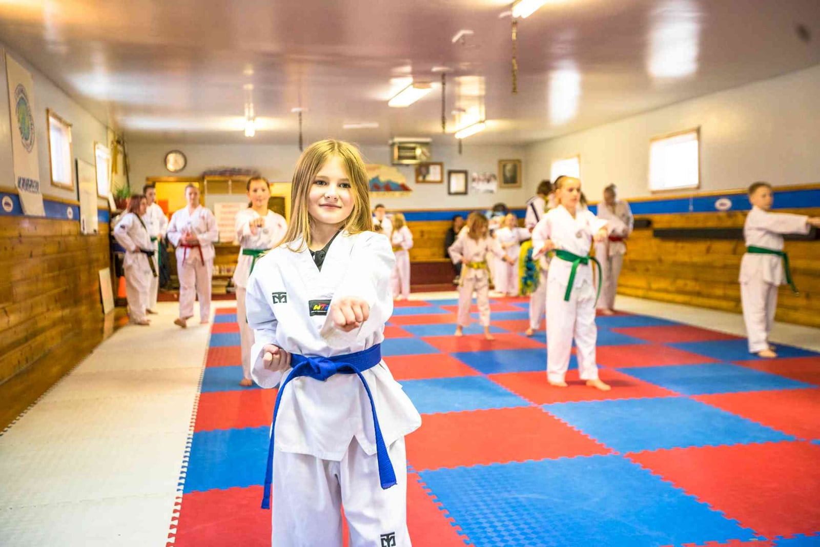 A young student in a blue belt holding a stance during kids taekwondo class at Rocky Mountain Martial Arts